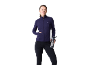 Femme en veste de sport bleu marine et legging noir, tenant une bouteille d'eau