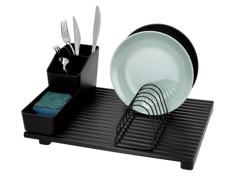 Égouttoir noir avec couverts, éponge et assiettes.