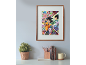 Poster d'anime encadré accroché au mur au-dessus d'un bureau avec plante et livres.