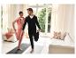 Un couple présente des vêtements de sport confortables dans un cadre domestique.