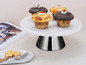 Quatre cupcakes sur un présentoir à gâteaux blanc.