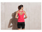 Femme portant un haut de sport rose et un short de cycliste noir.