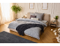 Chambre élégante avec linge de lit gris, jeté de lit décoratif et tapis assorti