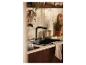 Évier de cuisine moderne avec robinet noir et accessoires de style naturel.