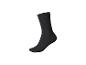 Une seule chaussette noire, debout verticalement sur un fond blanc.