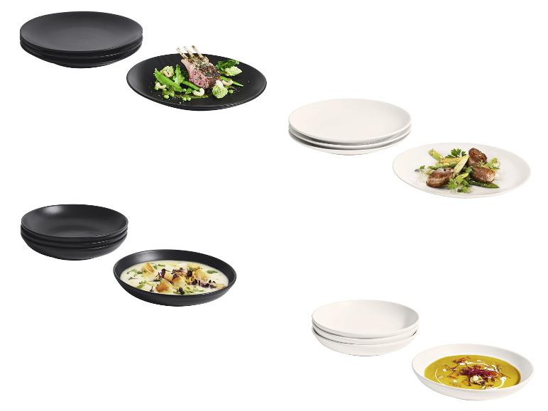 Assiettes et bols en céramique noirs et blancs avec plat d'agneau, légumes et soupes
