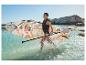 Femme en gilet de sauvetage avec paddleboard et pagaie dans l'eau.