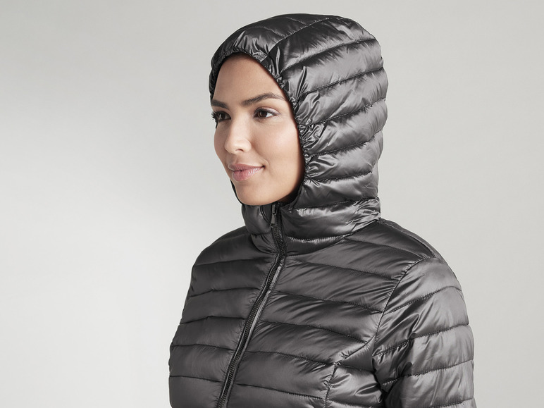 Une femme portant une veste matelassée noire à capuche.