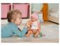 Une fille donne un biberon à une poupée Baby Born.