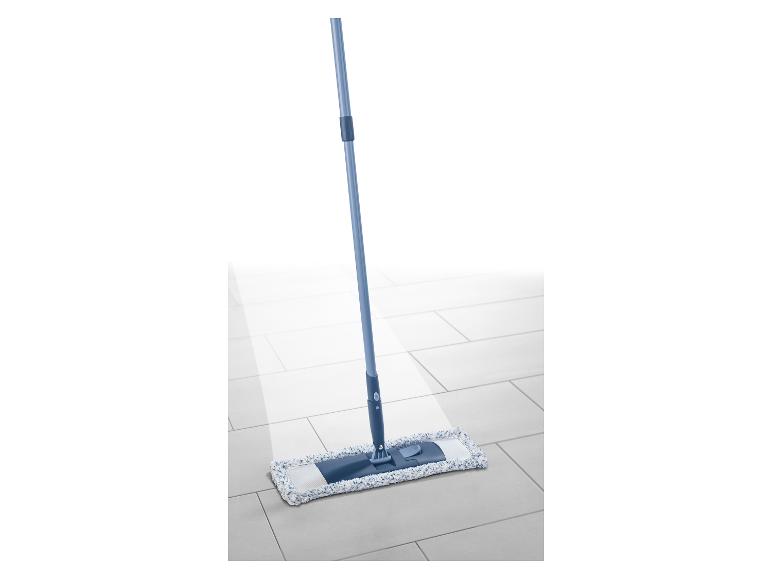 Un balai plat avec un manche bleu et une tête en microfibre blanche et bleue sur un sol carrelé.