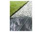 Gazon artificiel, galets blancs et toile de paillage noire.