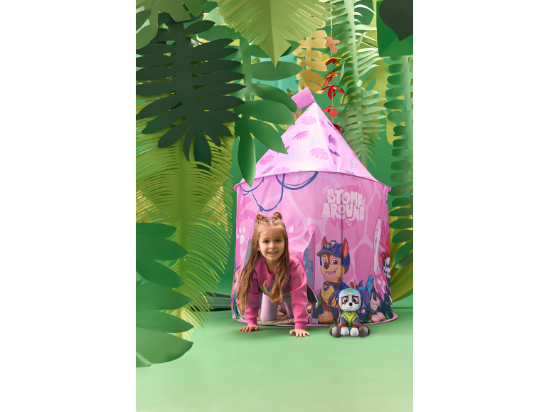 Fille joue dans une tente de jeu rose dans une chambre thème jungle avec une peluche.