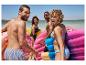 Des amis sur la plage avec des flotteurs en forme de donut et de glace.