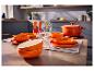 Cocotte en fonte orange SILVERCREST® et vaisselle sur une table dressée.