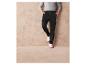 Pantalon cargo noir avec des baskets blanches.