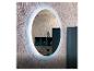 Miroir ovale éclairé avec lumière LED, reflétant des étagères et accessoires de salle de bain.