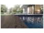 Terrasse moderne avec des lames de terrasse composites foncées et une piscine, entourée de verdure.