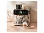 Machine à expresso avec moulin intégré, pot à lait moussé et café latte sur une table en bois.