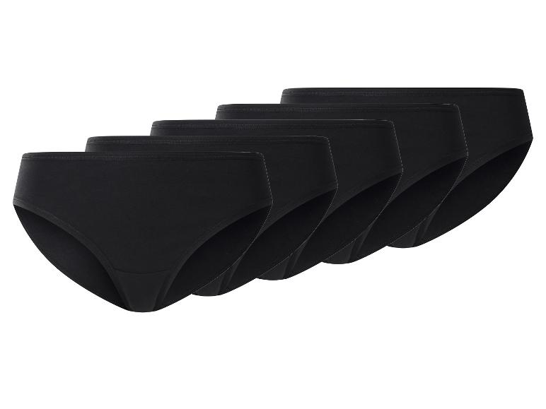 Cinq culottes noires pour femmes, soigneusement empilées et étalées.
