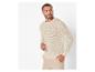 Un homme porte un pull beige à structure ajourée.
