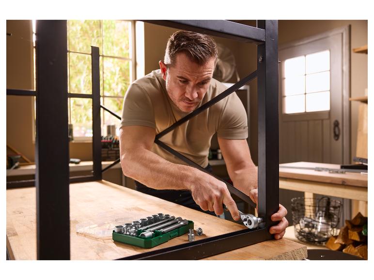 Homme assemblant une étagère métallique avec un jeu de clés à douille.