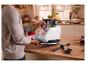 Homme préparant un repas avec un robot de cuisine dans une cuisine décorée pour Noël.