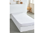 Drap-housse blanc sur un lit avec sommier blanc dans une chambre minimaliste.