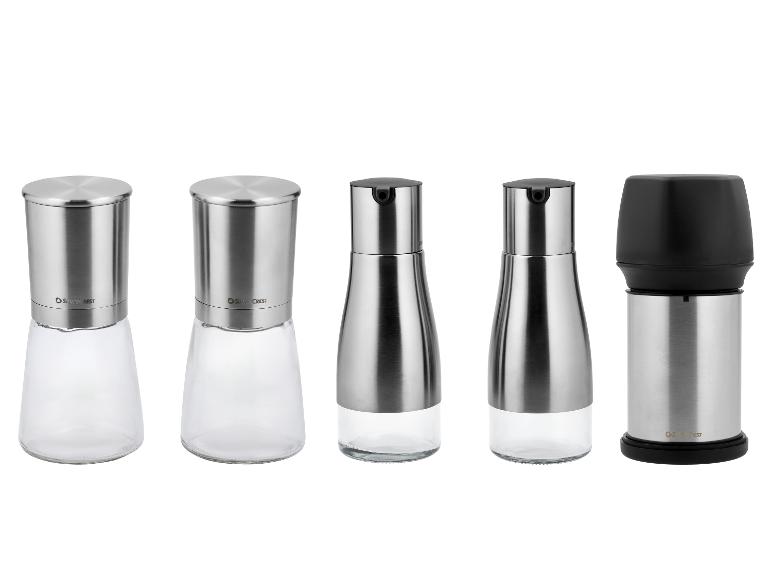 Cinq moulins à sel et à poivre en acier inoxydable et verre.