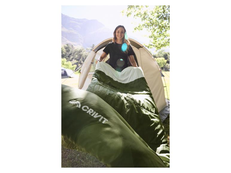 Femme souriante installant une tente et un sac de couchage en extérieur ensoleillé.