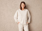 Une femme portant un sweat à capuche et un pantalon crème.