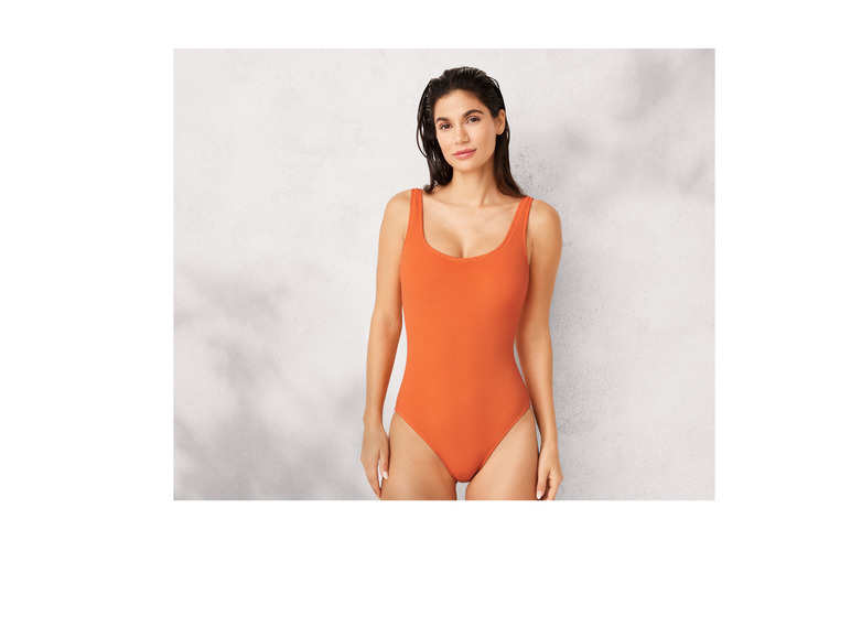 Une femme porte un maillot de bain orange.
