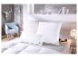 Chambre avec literie blanche, oreillers et couette, une chaise bleu clair et une décoration murale argentée.