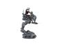 Une figurine d'action Mandalorien chevauchant un jouet marcheur AT-ST gris.