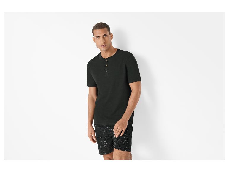 Pyjama homme : t-shirt henley foncé et short imprimé.