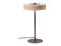 Lampe de table moderne avec abat-jour rond beige et base en métal foncé.