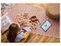 Enfant construisant un ensemble LEGO sur le sol avec une tablette affichant les instructions.