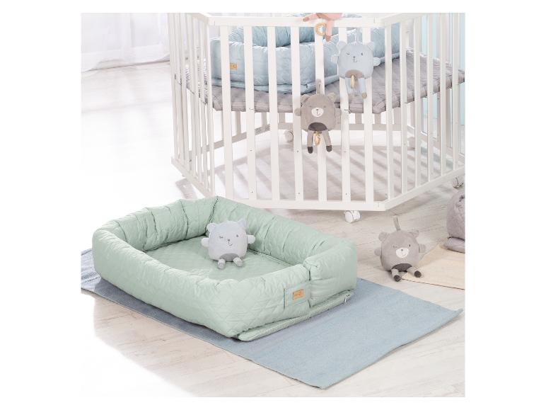Lit bébé en bois blanc à roulettes et nid bébé vert menthe avec jouets ours.