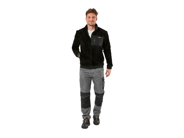 Homme en veste polaire noire et pantalon de travail gris