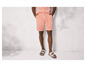 Un homme portant un short rayé et des sandales.