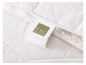 Une couette blanche avec une fermeture éclair et une étiquette 'TXL Wool Comfort'.