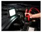 Lampe de travail LED et câbles de démarrage connectés à une batterie de voiture.