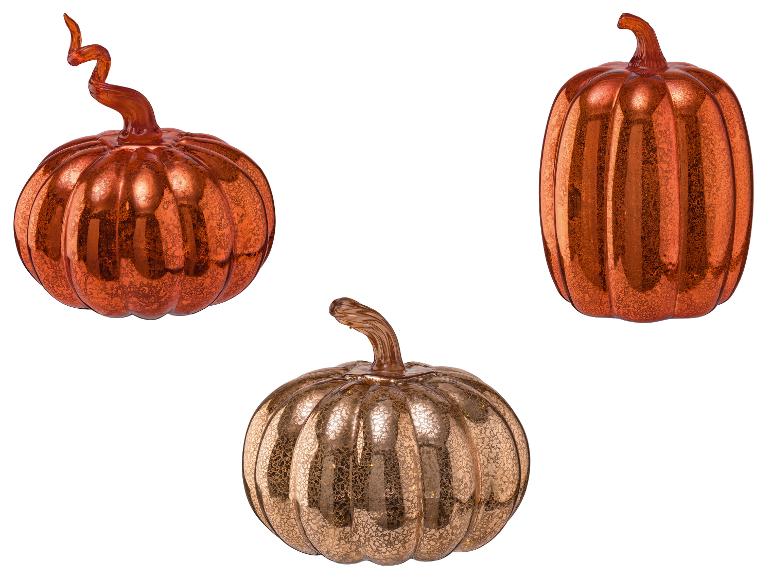 Trois citrouilles décoratives en verre dans des tons variés d'orange et d'or.