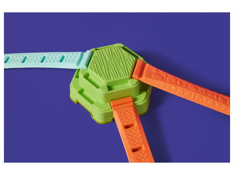 Jouet de construction avec base verte et trois sangles colorées : turquoise et deux oranges.