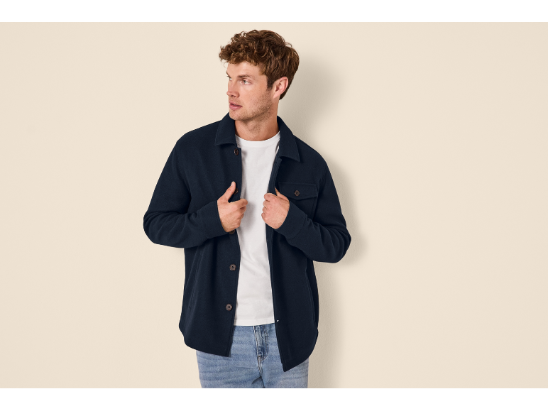 Homme portant une surchemise bleu marine, un t-shirt blanc et un jean.