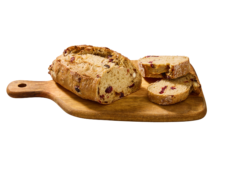 Tranches de pain rustique aux canneberges et noix sur une planche à découper en bois