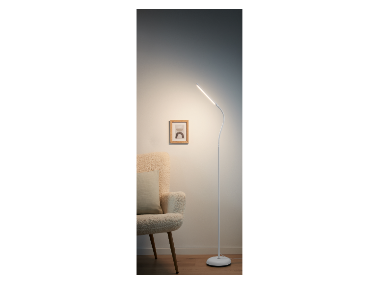 Lampe sur pied LED blanche moderne à côté d'un fauteuil.