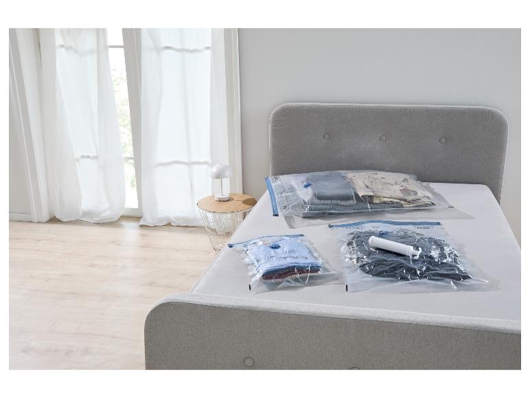 Sacs sous vide pour ranger les vêtements sur un lit, avec pompe.