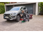 Homme changeant les pneus de voiture, utilisant un cric et une clé à chocs électrique.