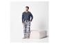 Homme en t-shirt bleu à manches longues et pantalon de pyjama à carreaux, debout à côté d'un pouf.