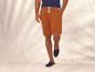 Un homme portant un short orange et des baskets bleues.